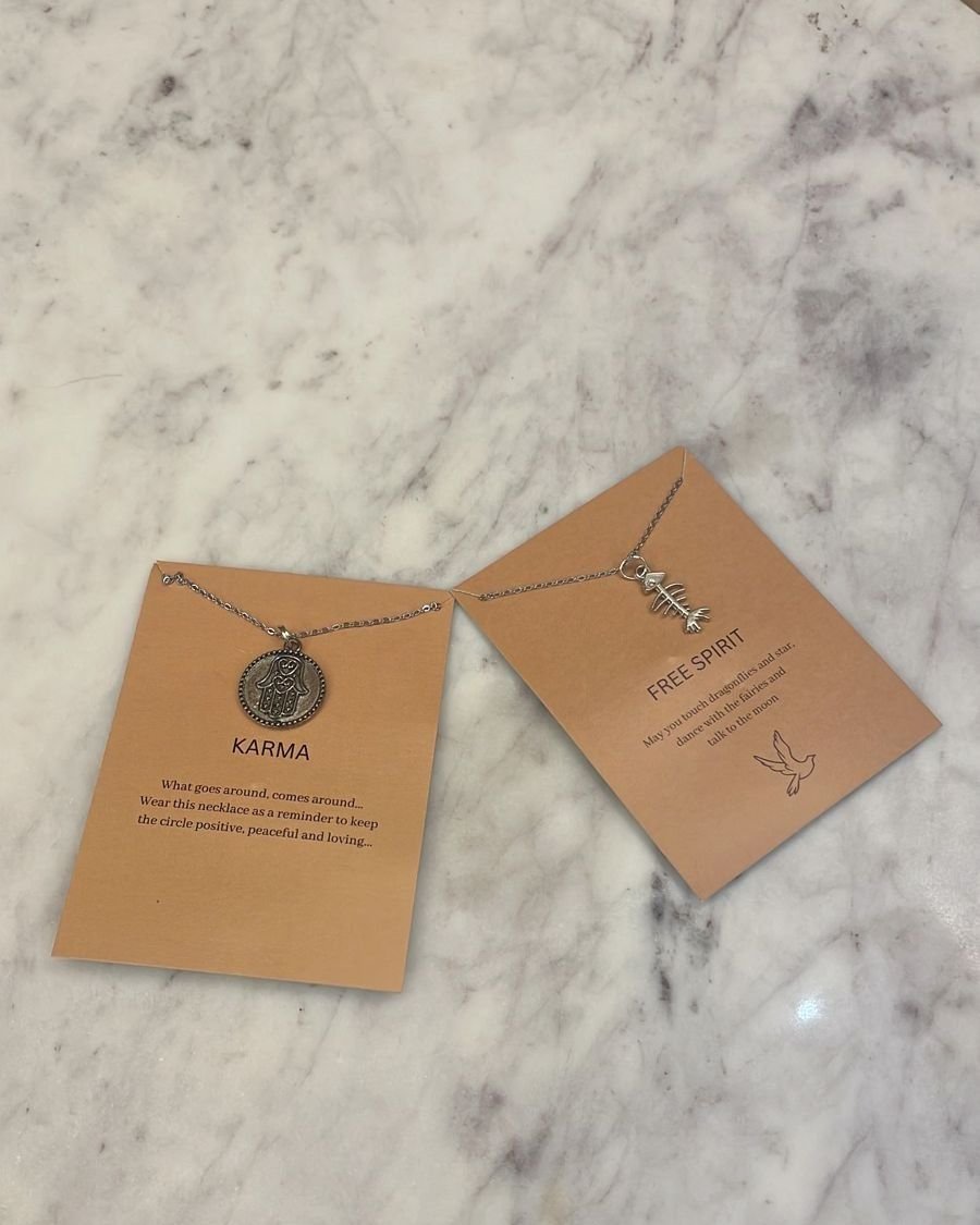 Pendants on Karma gift cards on a marble table